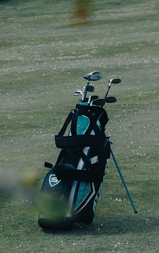 Fotografía de una bolsa de golf con trípode sobre el green de un campo de golf